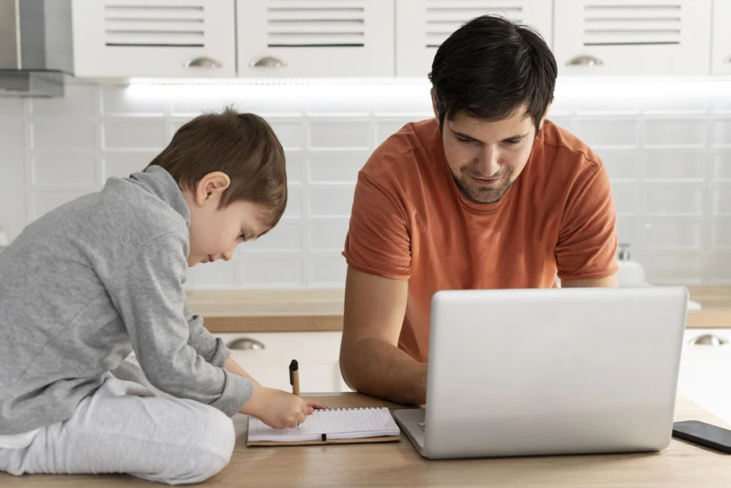 imagem de homem estudando no balcão da cozinha com seu filho do lado - Como estudar trabalhando 8 horas por dia