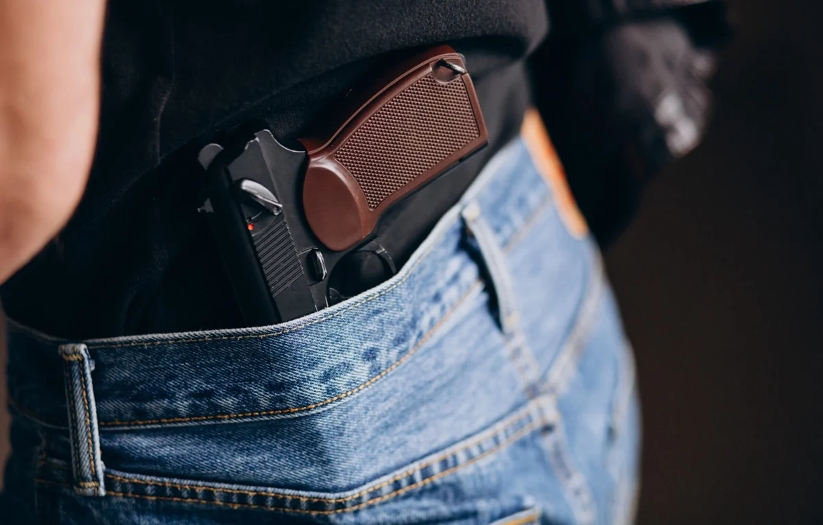 imagem de uma pessoa com arma de fogo na cintura da calça - Edital PPMG 2025 PDF