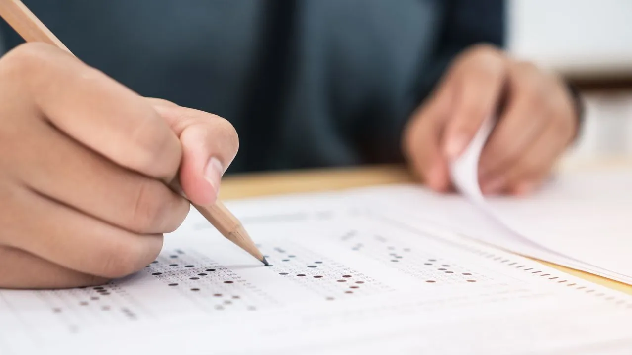 imagem de uma pessoa segurando lápis e preenchendo gabarito Concurso Banco do Brasil